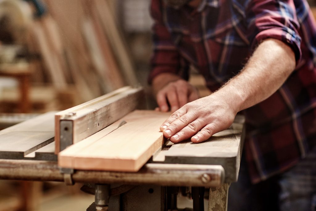 Craftsman using traditional woodworking tools to build custom furniture